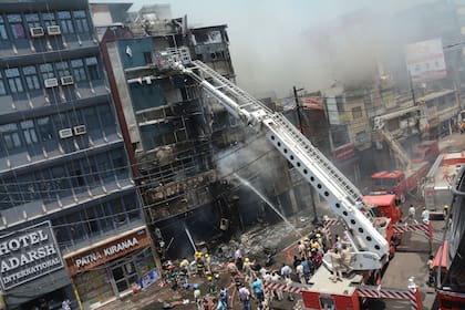 Bomberos trabajan en la extinción de un incendio en un restaurante y un hotel junto a la estación de tren de Patna, en el estado de Bihar, India, el 25 de abril de 2024. (AP Foto/Aftab Alam Siddiqui)