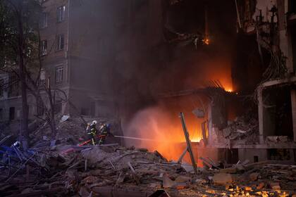 Bomberos tratan de sofocar un incendio tras una explosión, en Kiev, Ucrania, el 28 de abril de 2022. (AP Foto/Emilio Morenatti)