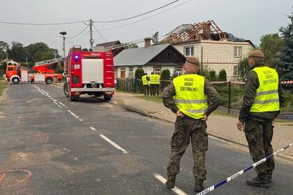 Bomberos y militares polacos cerca del lugar donde impactaron los restos de un dron ruso derribado (Archivo)
