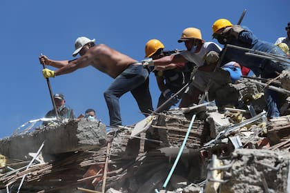 Bomberos y rescatistas remueven escombros