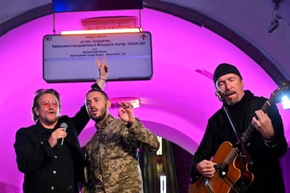 Bono y The Edge junto a Taras Topolia, líder de la banda Antytila, y ahora militar del ejército ucraniano, actúan en el metro. estación que es un refugio antiaéreo, en el centro de la capital ucraniana de Kiev el 8 de mayo