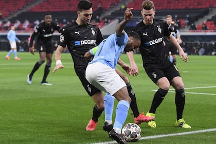 Raheem Sterling, el capitán de Manchester City, maniobra ante dos defensores de Borussia Moenchengladbach; el cuadro inglés fue nítidamente superior.