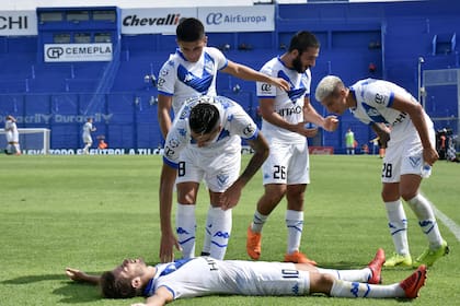 Bouzat, tendido, es felicitado por sus compañeros. El volante anotó el primer gol de Vélez.