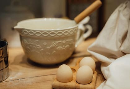 Bowl al lado de unos huevos sobre una base de madera