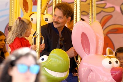 Bradley Cooper junto a su hija Lea en una calesita en el parque de diversiones Disneyland