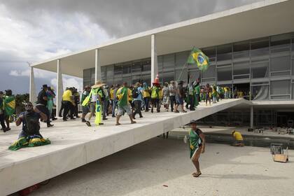 BRASILIA, BRAZIL - JANUARY 08: Supporters of former President Jair Bolsonaro clash with security forces as they break into Planalto Palace and raid Supreme Court in Brasilia, Brazil, 08 January 2023. Groups shouting slogans demanding intervention from the army broke through the police barrier and entered the Congress building, according to local media. Police intervened with tear gas to disperse pro-Bolsonaro protesters. Bolsonaro supporters managed to invade and ransack the National Congress, Planalto Palace, or President's office, and the Supreme Federal Court. (Photo by Joedson Alves/Anadolu Agency via Getty Images)