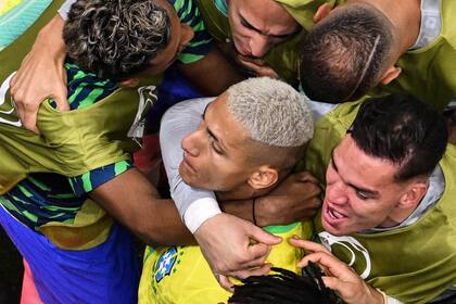 El delantero brasileño Richarlison celebra con sus compañeros de equipo, después de marcar el primer gol de su equipo durante el partido de fútbol del Grupo G, de la Copa Mundial de Qatar 2022