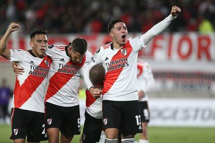 Brazos en alto de Enzo Fernández, que abraza a Nicolás De la Cruz (tapado), autor del primer gol de River a Colo Colo por la Copa Libertadores; se suman Bruno Zuculini y Esequiel Barco.
