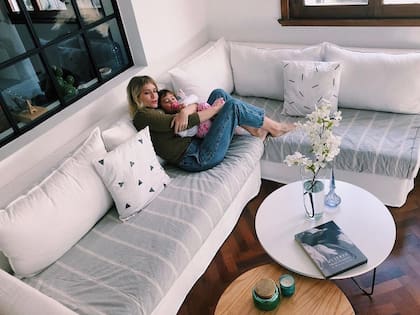 Brenda Gandini junto a su hija Alfonsina en el living de su casa