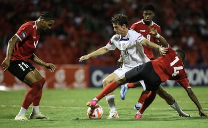 Brenden Aaronson de los Estados Unidos pelea por el balón con Shannon Gomez de Trinidad y Tobago en el encuentro de cuartos de final de la Liga de Naciones CONCACAF el lunes 20 de noviembre del 2023 en Puerto Príncipe, Trinidad y Tobago. (AP Foto/Azlan Mohammed)