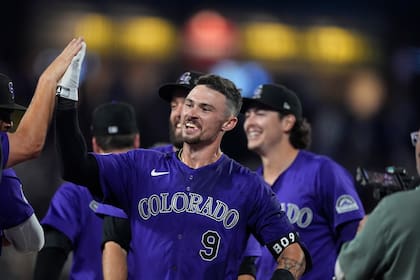 Brenton Doyle, de los Rockies de Colorado, festeja con sus compañeros tras conectar el elevado que significó el triunfo ante los Dodgers de Los Ángeles, el miércoles 19 de junio de 2024 (AP Foto/David Zalubowski)