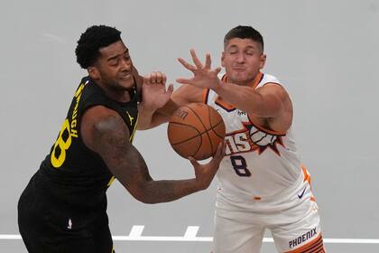 Brice Sensabaugh del Jazz de Utah, izquierda, y Grayson Allen (8) de los Suns de Phoenix pelean por el balón durante la primera mitad en la NBA Cup, el martes 12 de noviembre de 20204, en Salt Lake City. (AP Photo/Rick Bowmer)