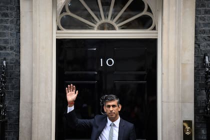 Rishi Sunak saluda frente a la puerta de Downing Street 10 después de pronunciar su primer discurso como primer ministro