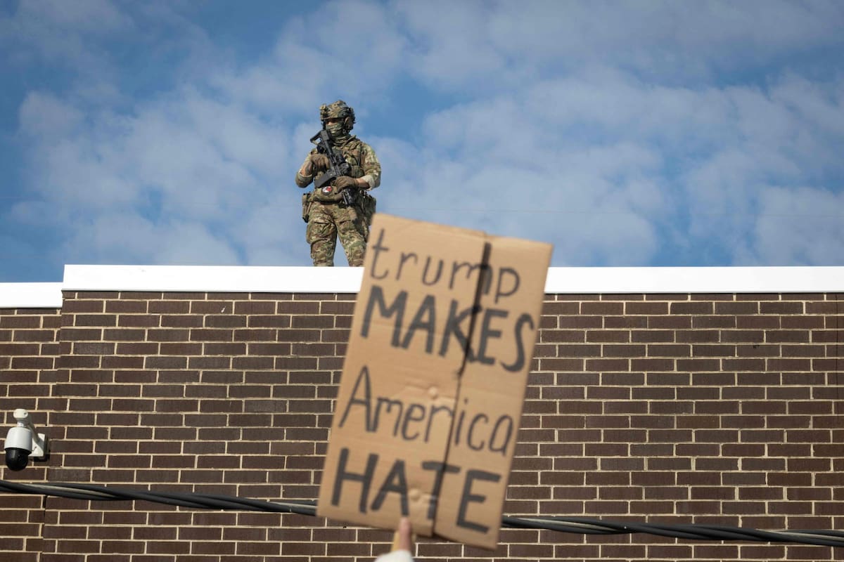 BROADVIEW, ILLINOIS - 12 DE SEPTIEMBRE: Agentes de la policía federal observan desde la azotea a manifestantes que protestan frente a un centro de procesamiento de inmigración el 12 de septiembre de 2025 en Broadview, Illinois