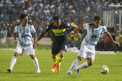 Bruno Bianchi intenta dominar el balón ante Carlos Tevez; detrás, Guillermo Acosta