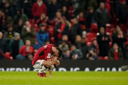 Bruno Fernandes de Manchester United en cuclillas tras quedar eliminados en la etapa de grupos de la Champions League al perder ante el Bayern Munich. (AP Foto/Dave Thompson)