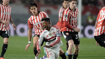 Bruno Henrique cae en medio de la disputa de la pelota con Baltasar Rodríguez y Alexis Castro, en el partido entre Estudiantes y Flamengo por las semifinales de la Copa Libertadores