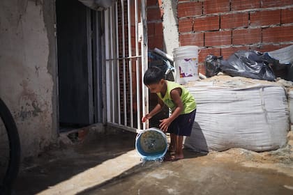 Bruno juega con el agua en su casa de Rincón de Milberg, en Tigre; tiene TEA y, desde que en su casa hay piso de cemento, su salud mejoró