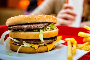 BUDAPEST, HUNGARY, April, 2013: Young woman eating a Big Mac hamburger menu in a McDonald's restaurant. Illustrative editorial.