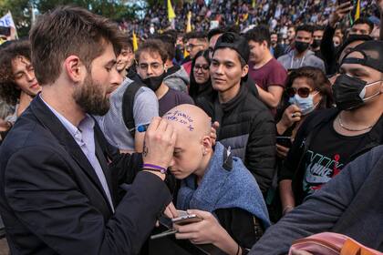 El youtuber “El Presto” firma la cabeza de un simpatizante de Milei durante un acto de campaña en Parque Lezama.