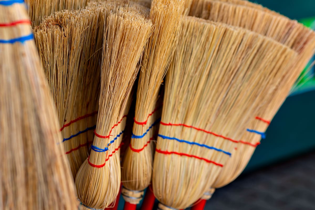 bunch of brooms with red and blue stripes the brooms are leaning against each other
