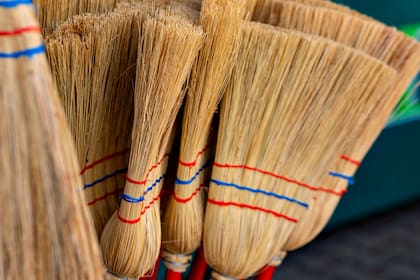 bunch of brooms with red and blue stripes the brooms are leaning against each other
