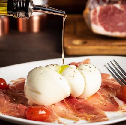 Burrata y Prosciutto con toque de aceite de oliva.