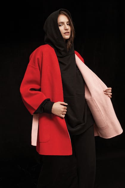 Buzo negro deportivo oversize de algodón con capucha (Levi's), pantalón estilo jogger de algodón (Giesso), tapado de lana reversible con mangas caídas oversize rojo y rosa (Las Pepas)