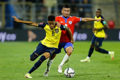 Byron Castillo, de Ecuador, y Jean Meneses, de Chile, pelean por el balón durante el partido de las Eliminatorias de la Copa Mundial de la FIFA Qatar 2022 en el Estadio San Carlos de Apoquindo, el 16 de noviembre en Santiago, Chile.