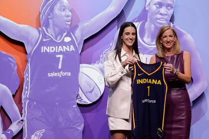 Caitlin Clark de Iowa, izquierda, posa para una foto con la comisionada de la WNBA, Cathy Engelbert, después de ser seleccionada en primer lugar por el Fever de Indiana durante la primera ronda del draft de baloncesto de la WNBA, el lunes 15 de abril de 2024, en Nueva York. (AP Foto/Adam Hunger)