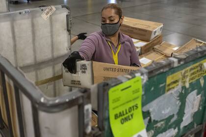 Cajas llenas de boletas por correo de Washington y Oregon en un centro de procesamiento y distribución del Servicio Postal de EE.UU. (USPS) en Portland, Oregon