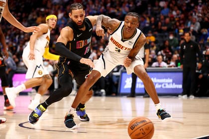 Caleb Martin, de Miami Heat, lucha por el balón con Bones Hyland, el chico que sobrevivió a un incendio en su casa en Wilmington