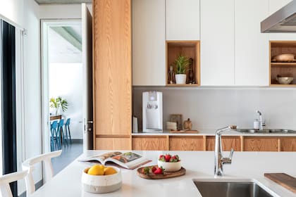 Cálida y funcional, la cocina es el centro de la casa. La cerámicas son de Nelipot y las banquetas de Marini Estudio.