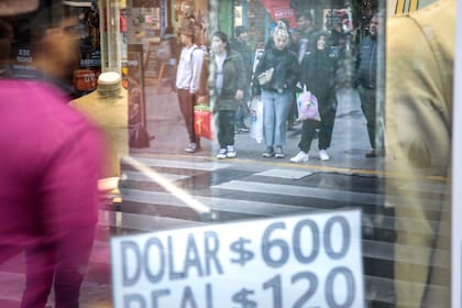 Calle Florida, negocios a la calle con carteles de la cotizacion del dólar blue o paralelo.