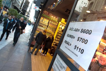 Calle Florida, negocios a la calle con carteles de la cotizacion del dólar blue o paralelo.