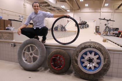 Calvin Young, uno de los ingenieros que participaron del desarrollo de METL, junto a los diferentes modelos de ruedas sin aire creados por la NASA