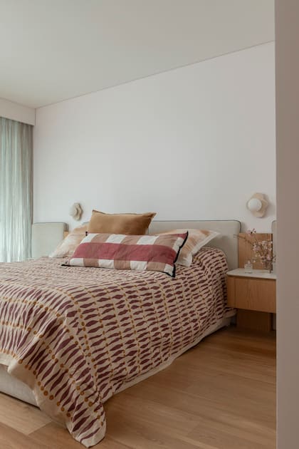 Cama con mesas de luz y respaldo a medida (Arq & Co). Acolchados y almohadones estampados a mano (Mercedes Segura).