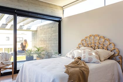 Cama con respaldo de mimbre (Guazú Nambí), almohadones y pie de cama (todo de En Abundancia), cortinas de tussor (Kutika Home).