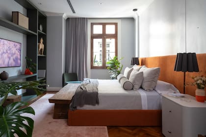 Cama con respaldo entelado y mesas de luz (todo de Urbano Estudio). Lámparas colgantes ‘Renata 32’ (Iluminación Agüero).