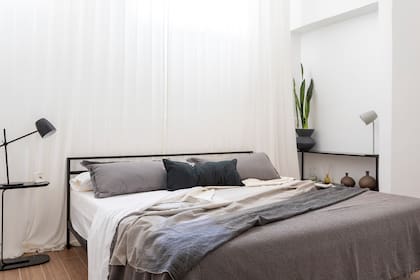Cama de hierro (Mercado Libre). Mesa con pie de hierro Ropa de cama (Lote Propio). Manta tejida (Quiero Norte).
