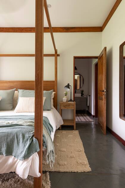 Cama de incienso con dosel y mesas de luz de petiribí, edredón, pies de cama de gasa, alfombra de lana artesanal (todo de L’Epicerie).