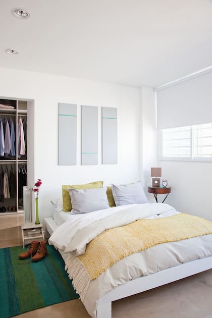 Cama laqueada, en sintonía con varios de los muebles. Pie de cama y alfombra (Graciela Churba).