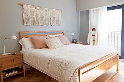 Cama (Larralde Spelzini) y tejido macramé (Nap Handmade), con mesas de luz (Bull) y lámparas (Iluminación Agüero). Para la pared eligieron el tono 'Dorian Gray 7017' de Sherwin Williams.