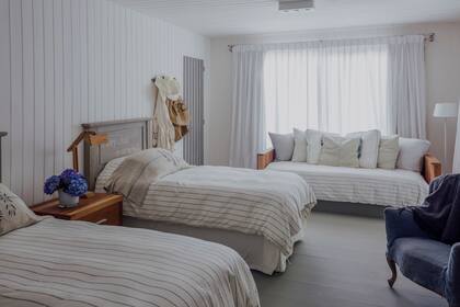 Camas (Sentido José Ignacio), lámpara articulada de madera (Santas Negras) y cortinas de lino.