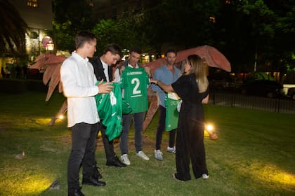 Camila Castagnola les reparte las camisetas para posar con ellas.
