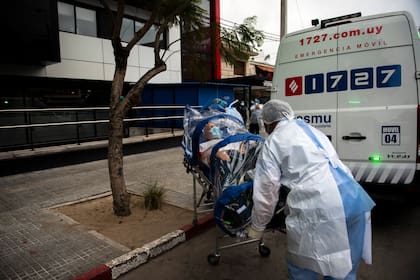 Camilleros del sistema médico Casmu trasladan a un paciente con sospechas de haber contraído el coronavirus, en Montevideo, el 21 de mayo