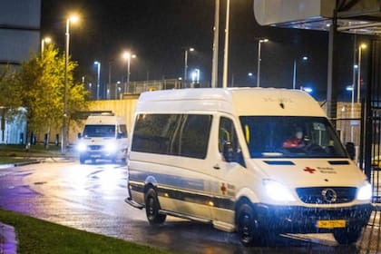 Camionetas de la Cruz Roja transportan hacia un hotel a pasajeros de vuelos desde Sudáfrica que dieron positivo al coronavirus a su llegada a Países Bajos