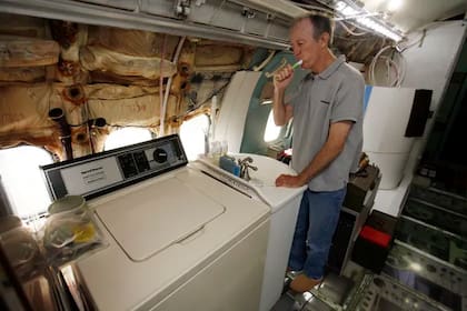 Campbell lavándose los dientes en el baño que acondicionó en la aeronave