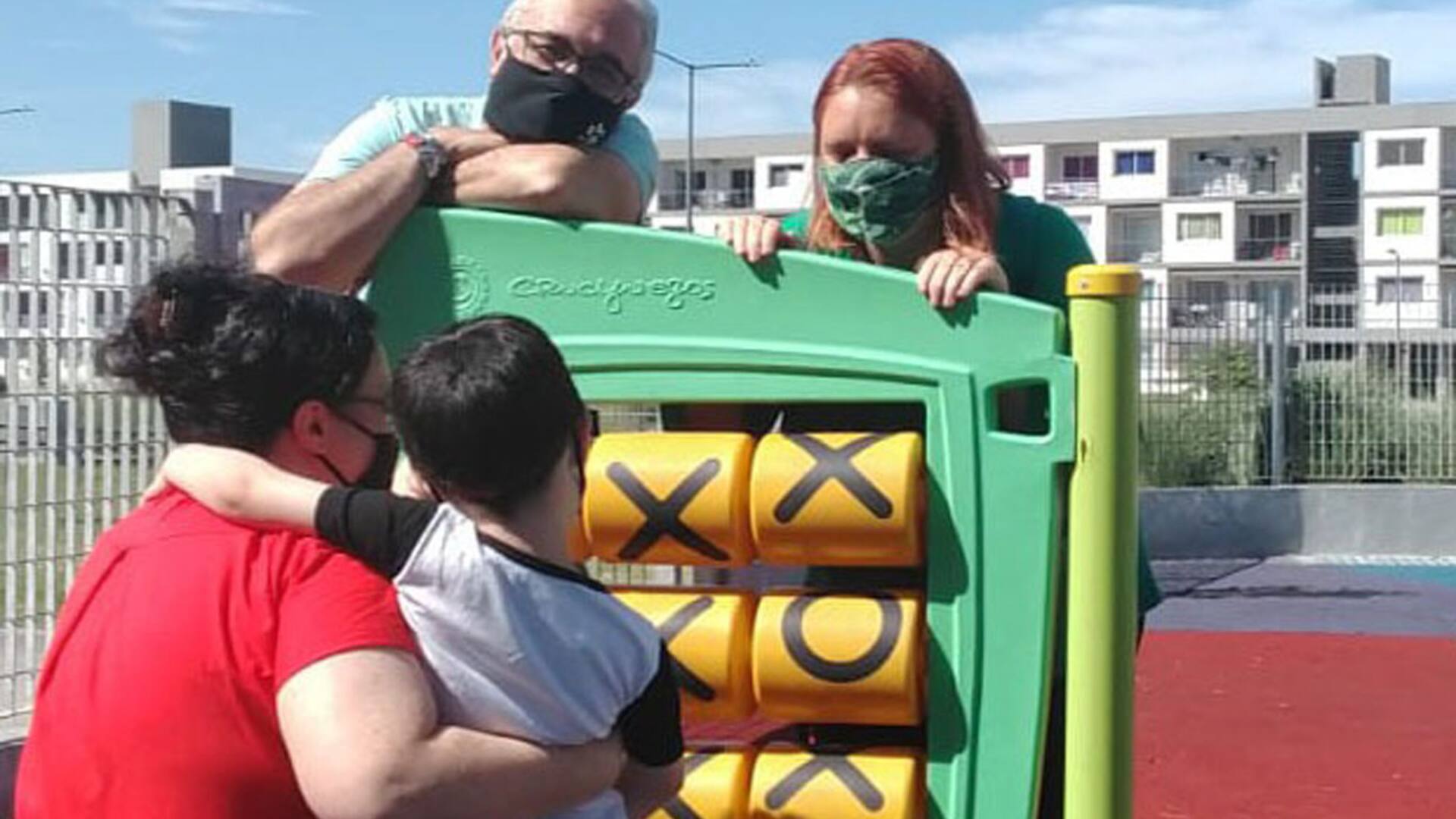 Marcelo, Cande y Joaquín, en una plaza de juegos en la ciudad de Buenos Aires