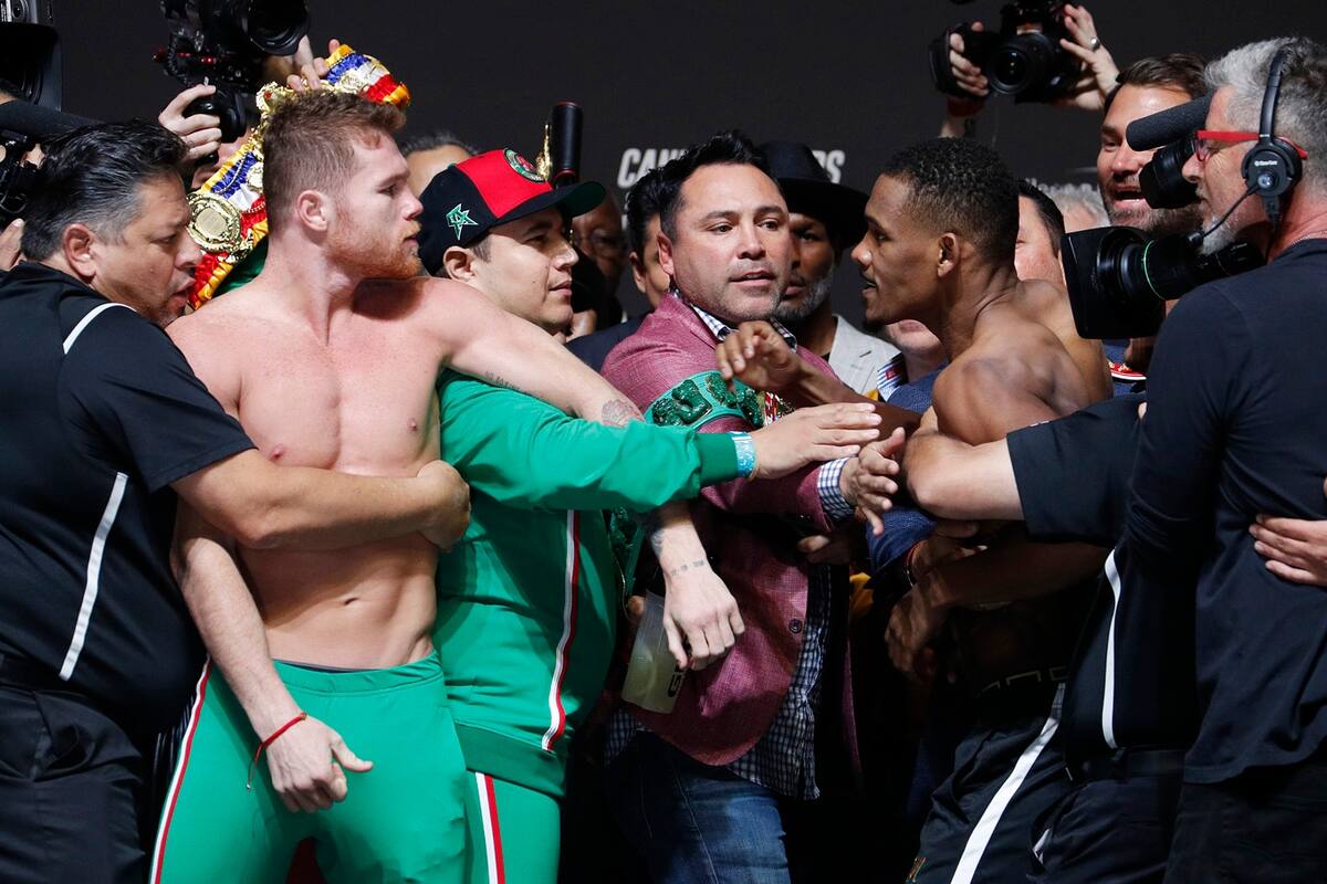 Canelo Álvarez y Daniel Jacobs durante el pesaje del viernes. En el medio, Oscar de la Hoya, el promotor.